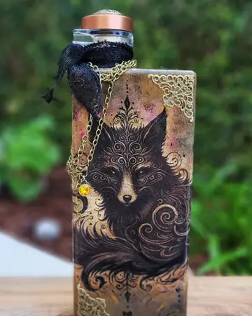 Dark bottle decorated with an intricate wolf illustration and gold detailing