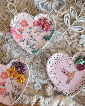 Fabric hearts embroidered with flowers and trimmed with lace, made as hanging ornaments