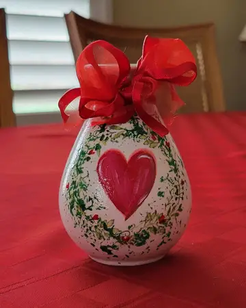 Frosted bottle painted with a red heart and tied with a red organza bow