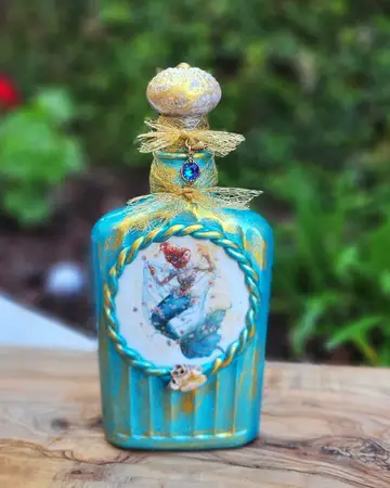 Teal bottle with a framed painted panel and a jewelled stopper
