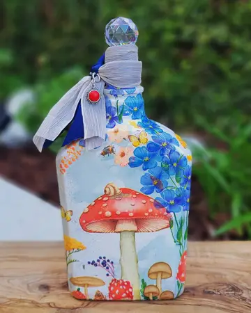 Pale bottle painted with toadstools and blue flowers