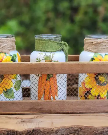 Sunflower-painted jars arranged in a wooden crate