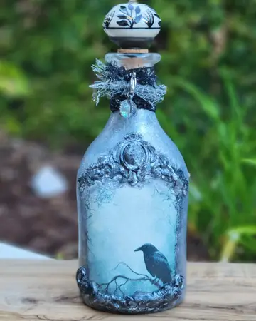 Blue bottle with a raven and a textured snowy finish