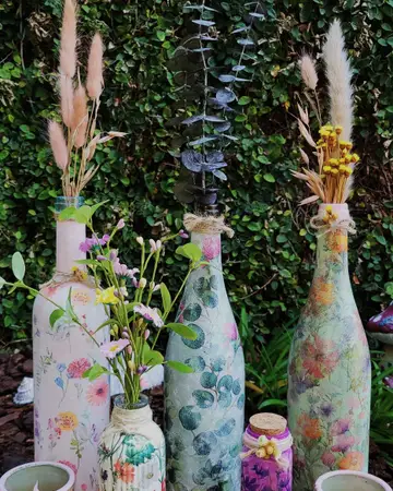 Painted bottle vases holding fresh garden stems