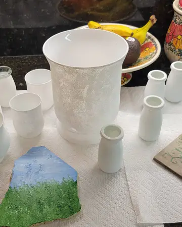 Blank pottery pieces set out ready to be painted at a workshop