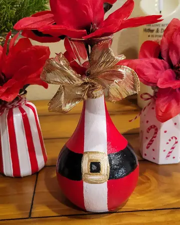 Santa-themed vases holding red poinsettias