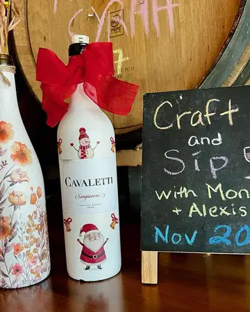 Decorated wine bottles beside a chalkboard sign for a Craft and Sip workshop