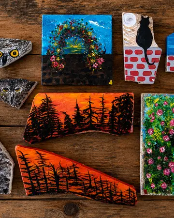 Painted tiles showing a woodland archway and a forest at sunset